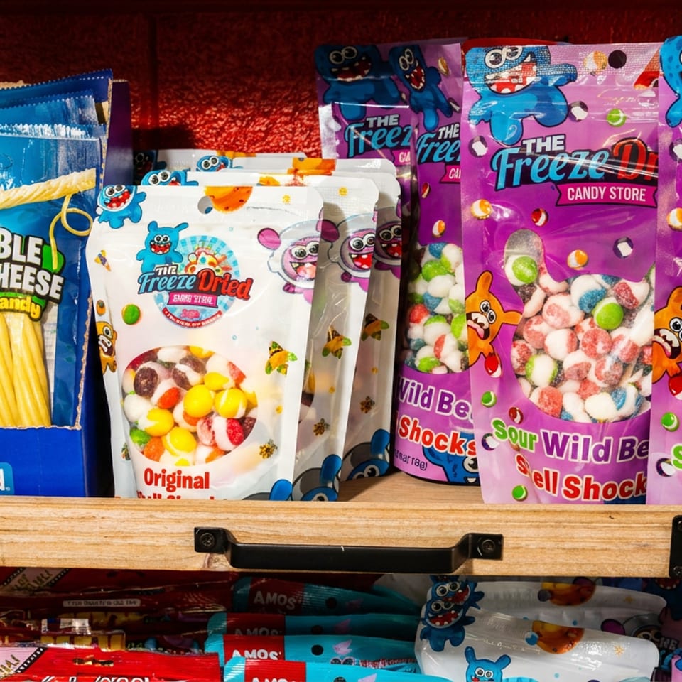 Colorful Freeze Dried candy bags and Frankford gummy candy displayed in a wooden crate.